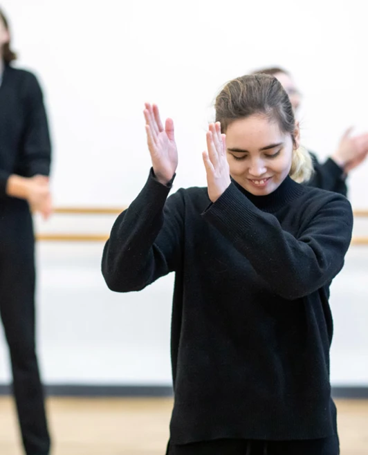 Female student clapping her hands with a bright smile during a drama or dance activity in the studio, feeling proud and accomplished. Female student clapping her hands with a bright smile during a drama or dance activity in the studio, feeling proud and accomplished.